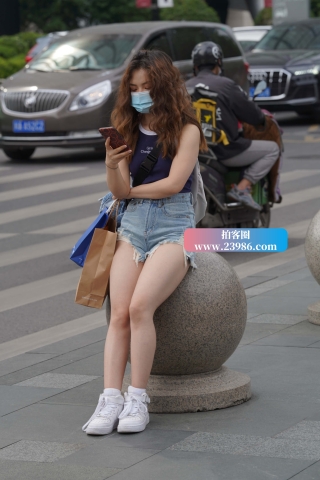 街拍坐石墩上玩手机的卷发美眉